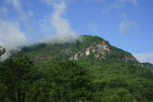 Morning mist burns off the geological formations in Chimney Rock Sate Park in Chimney Rock Village, N.C., on Wednesday, May 14, 2025. (AP Photo/Allen G. Breed)
