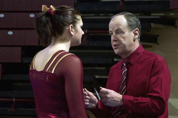 In this undated photo, then Central Michigan University gymnastics coach Jerry Reighard speaks with a gymnast in Mount Pleasant, Mich. A Michigan court on Thursday, May 12, 2022, has reinstated a lawsuit by Reighard, a former college gymnastics coach, who claims he was defamed on Twitter by an ESPN reporter linking him to disgraced sports doctor Larry Nassar and a controversial coach. (The Morning Sun via AP)