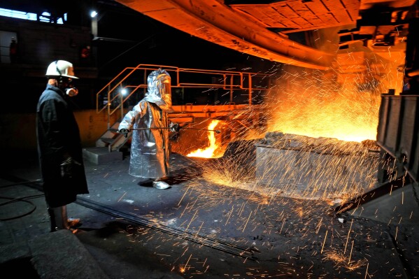 A worker in a protective suit pokes a metal rod to tap slag from a smelting furnace at PT Vale Indonesia's nickel processing plant in Sorowako, South Sulawesi, Indonesia, Tuesday, Sept. 12, 2023. A presidential election in Indonesia, the world's third-largest democracy, is highlighting the choices to be made as the country seeks to exploit its rich reserves of nickel and other resources that are vital to the global transition away from fossil fuels. (APPhoto/Dita Alangkara)