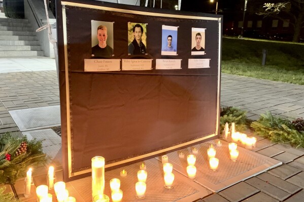 FILE - A memorial outside Leavitt Hall at Maine Maritime Academy in Castine, Maine, on Sunday, Dec. 11, 2022, honors four students who died in a fiery weekend SUV crash just off campus. A woman who survived the crash that claimed the lives of four Maine Maritime Academy students has been charged as an “accomplice or co-conspirator” in connection with the tragedy Hancock County district attorney said Friday, Aug. 18, 2023. (Ethan Genter/The Bangor Daily News via AP)