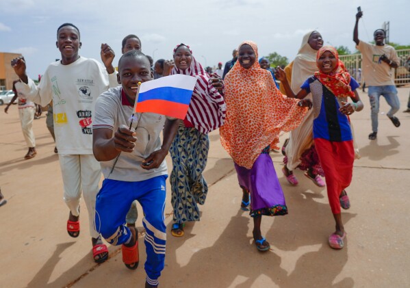 Supporters of Niger's ruling junta hold a Russian flag in Niamey, Niger, Sunday, Aug. 6, 2023. Nigeriens are bracing for a possible military intervention as time's run out for its new junta leaders to reinstate the country's ousted president. (AP Photo/Sam Mednick)