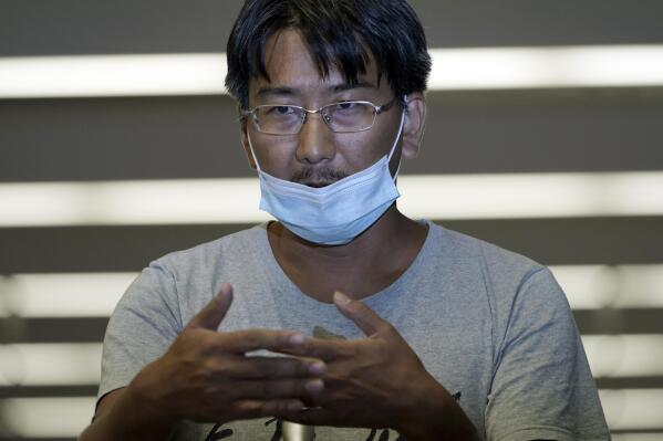 Yuki Kitazumi, a Japanese freelance journalist detained by security forces in Myanmar in mid-April and accused of spreading fake news criticizing the military coup gestures to speak upon his arrival at Narita International Airport, in Narita, east of Tokyo. (AP Photo/Eugene Hoshiko)