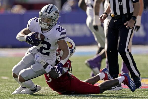 Kansas State running back Deuce Vaughn (22) is tackled by Kansas safety Ricky Thomas Jr. (3) during the first half of an NCAA football basketball game Saturday, Nov. 6, 2021, in Lawrence, Kan. (AP Photo/Charlie Riedel)