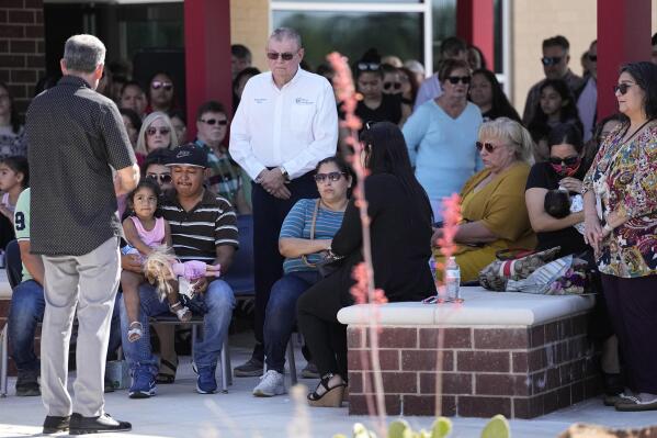 Mass shooting survivor Wilson Garcia, left wearing striped shirt, takes part in a vigil for his son, Daniel Enrique Laso, Sunday, April 30, 2023, in Cleveland, Texas. Garcia's son and wife were killed in the shooting Friday night. The search for a Texas man who allegedly shot his neighbors after they asked him to stop firing off rounds in his yard stretched into a second day Sunday, with authorities saying the man could be anywhere by now. The suspect fled after the shooting Friday night that left multiple people dead, including the young boy. (AP Photo/David J. Phillip)
