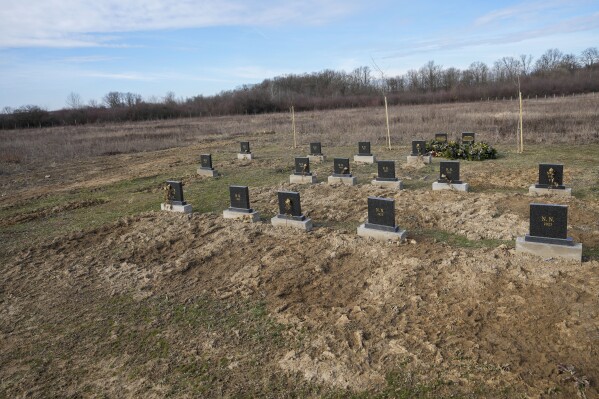 The gravestones under which unidentified remains of 41 people retrieved from the river since 2017, are seen at the cemetery in Bijeljina, eastern Bosnia, Sunday, Feb. 4, 2024. In several cities along this river between Bosnia and Serbia, simple, durable gravestones now mark the final resting places of dozens of refugees and migrants who drowned in the area while trying to reach Western Europe. (AP Photo/Darko Vojinovic)