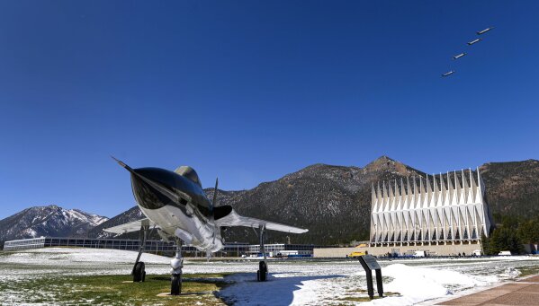 Four F-35A fighter jets fly over the Air Force Academy in Colorado Springs, Colo., Friday, April 17, 2020, to honor the Class of 2020 who will graduate early in a closed ceremony Saturday on the terrazzo at the center of campus rather than Falcon Stadium. The early graduation on the terrazzo will allow them to stay 8 feet apart during the COVID-19 pandemic. Vice President Mike Pence will speak in person, but the cadets won't march up to receive diplomas and high fives and hugs are banned. The Thunderbirds will fly over at the conclusion of the ceremony that will be streamed online for families and friends. In the foreground is a Republic F-105D Thunderchief, the first supersonic tactical fighter-bomber developed from scratch. The first F-105D Thunderchief flew in 1959 and played a major role in the Vietnam War. (Christian Murdock/The Gazette via AP)
