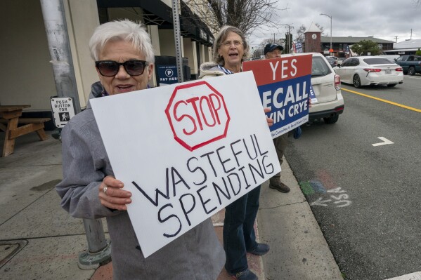 Judy Salter, left, joins others in a demonstration calling for the recall of Shasta County Supervisor Kevin Crye, in Redding, Calif., on Tuesday, Feb. 20, 2024. Crye is one of the board members who voted to get rid of the county's ballot-counting machines in favor of counting ballots by hand. Salter is one of the organizers of the recall. (AP Photo/Rich Pedroncelli)