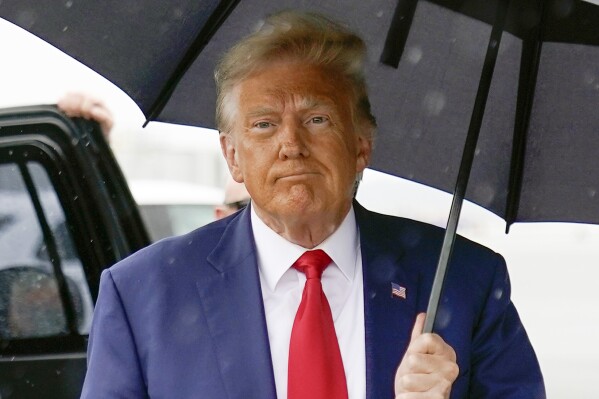 FILE —Former President Donald Trump walks to speak with reporters before boarding his plane at Ronald Reagan Washington National Airport, Aug. 3, 2023, in Arlington, Va. A federal judge tossed out former President Donald Trump's countersuit against columnist E. Jean Carroll who won a sex abuse lawsuit against him, ruling Monday, Aug. 7, 2023, that Trump can't claim she defamed him by continuing to say she was not only sexually abused but raped. (AP Photo/Alex Brandon, File)