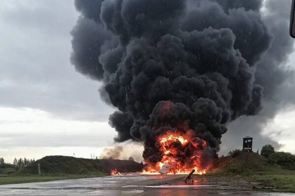 In this image released by Sirena telegram channel on Sunday, Aug. 20, 2023, a Russian warplane is burning on the Soltsy air base in the Novgorod region in northwestern Russia. Ukrainian saboteurs coordinated by Kyiv's military intelligence services carried out a pair of recent drone attacks that hit parked bomber aircraft at air bases deep inside Russia, Ukraine media claimed Tuesday. The attacks on Russian airfields on Saturday and Monday destroyed two Russian bombers and damaged two other aircraft, according to Ukrainska Pravda, as the war approaches its 18-month milestone. (Sirena telegram channel via AP)