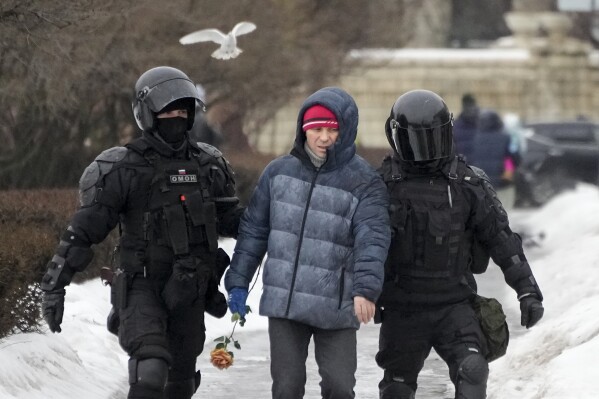 FILE - Police detain a man who wants to lay flowers paying last respects to Alexei Navalny at a large boulder from the Solovetsky islands, where the first camp of the Gulag political prison system was established, in St. Petersburg, Russia on Saturday, Feb. 17, 2024. (AP Photo, File)