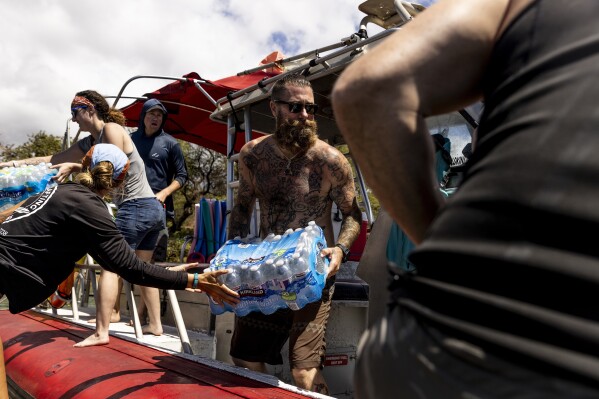 FILE - Volunteers load supplies onto a boat for West Maui at the Kihei boat landing, after a wildfire destroyed much of the historical town of Lahaina, on the island of Maui, Hawaii, Aug. 13, 2023. When the most deadly U.S. fire in a century ripped across the Hawaiian island, it damaged hundreds of drinking water pipes, resulting in a loss of pressure that likely allowed toxic chemicals along with metals and bacteria into water lines. Experts are using strong language to warn Maui residents in Lahaina and Upper Kula not to filter their own tap water. (Stephen Lam/San Francisco Chronicle via AP, File)