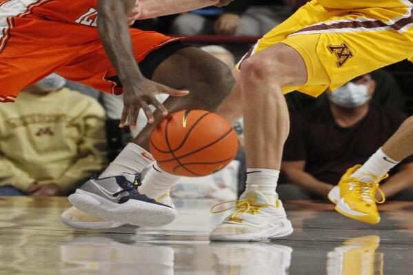 Illinois guard Da'Monte Williams (20) works around Minnesota forward Jamison Battle (10) during the first half of an NCAA college basketball game Tuesday, Jan. 4, 2022, in Minneapolis. (AP Photo/Bruce Kluckhohn)
