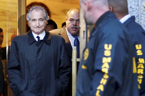 FILE - Disgraced financier Bernard Madoff leaves U.S. District Court in Manhattan after a bail hearing in New York, Monday, Jan. 5, 2009. Madoff, the financier who pleaded guilty to orchestrating the largest Ponzi scheme in history, died early Wednesday, April 14, 2021,  in a federal prison, a person familiar with the matter told The Associated Press.  (AP Photo/Kathy Willens, File)