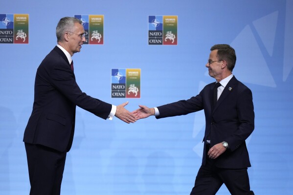 FILE - NATO Secretary General Jens Stoltenberg, left, greets Sweden's Prime Minister Ulf Kristersson during arrivals for a NATO summit in Vilnius, Lithuania, on July 11, 2023. Swedish Prime Minister Ulf Kristersson tells his Hungarian counterpart Viktor Orbán that more dialogue would be beneficial after Orbán invited the Swede to Budapest to discuss Sweden's NATO accession. (AP Photo/Pavel Golovkin, File)