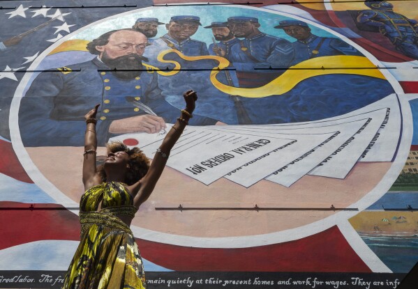 FILE - Dancer Prescylia Mae, of Houston, performs during a dedication ceremony for the massive mural "Absolute Equality" in downtown Galveston, Texas, Saturday, June 19, 2021. The dedication of the mural, which chronicles the history and legacy of Black people in the United States, was one of several Juneteenth celebrations across the city. (Stuart Villanueva/The Galveston County Daily News via AP, file)