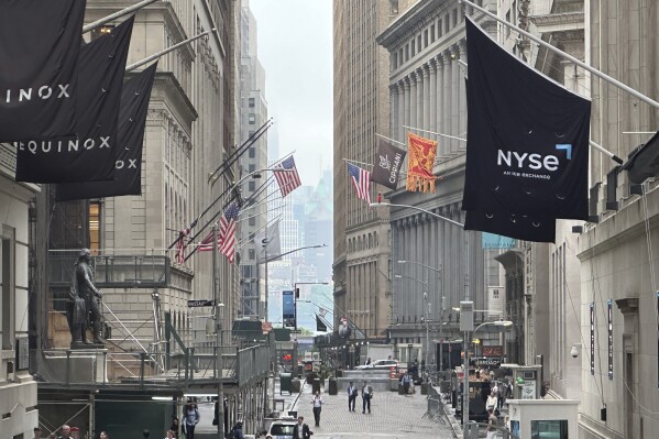 The New York Stock Exchange, right, is shown in this view looking east on Wall St. on Wednesday, June 5, 2024. Global shares are mixed as investors weigh data highlighting a slowing U.S. economy that offers both upsides and downsides for Wall Street. (AP Photo/Peter Morgan, File)