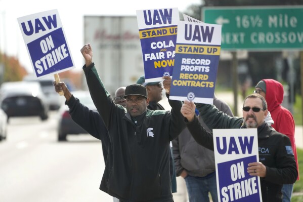 FILE - United Auto Workers members walk the picket line during a strike at the Stellantis Sterling Heights Assembly Plant, in Sterling Heights, Mich., Monday, Oct. 23, 2023. A six-week United Auto Workers strike at Ford cut sales by about 100,000 vehicles and cost the company $1.7 billion in lost profits this year, Ford said Thursday, Nov. 30, 2023. (AP Photo/Paul Sancya, File)