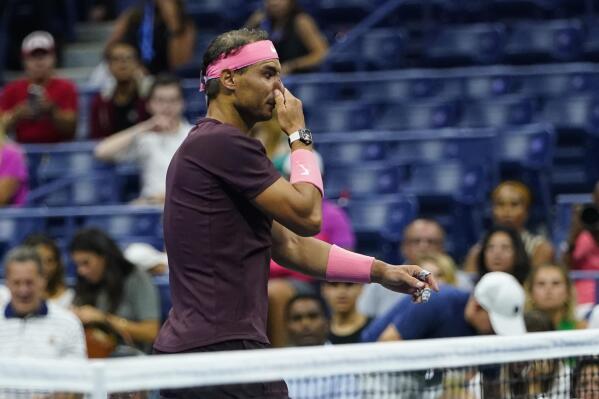 Rafael Nadal, of Spain, holds his nose after it was struck by his racket, during a medical timeout during a match against Fabio Fognini, of Italy, during the second round of the U.S. Open tennis championships, early Friday, Sept. 2, 2022, in New York. (AP Photo/Frank Franklin II)
