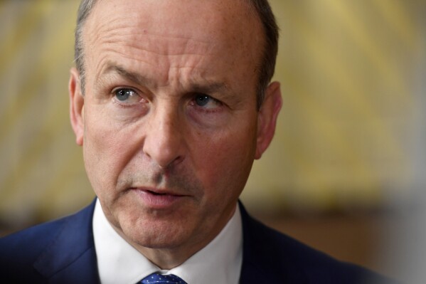 FILE - Ireland's Prime Minister Micheal Martin speaks with the media as he arrives for an EU summit in Brussels, Thursday, Oct. 20, 2022. Ireland's government said Wednesday, Dec. 20, 2023, that it will take legal action against British authorities over a controversial law that gives some immunity from prosecution for offenses committed during three decades of sectarian violence.(AP Photo/Geert Vanden Wijngaert, File)