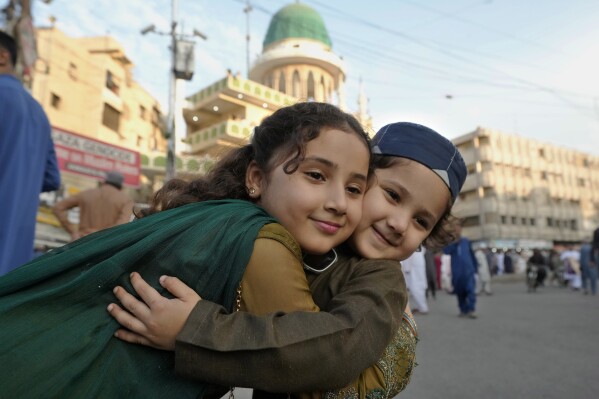 イスラム教徒の子供たちは、2024年4月10日水曜日、パキスタンのカラチで断食月のラマダンの終わりを記念するイード・アル・フィトルの祈り会に出席し、イードの挨拶を交わしています。  （AP写真/Fareed Khan）