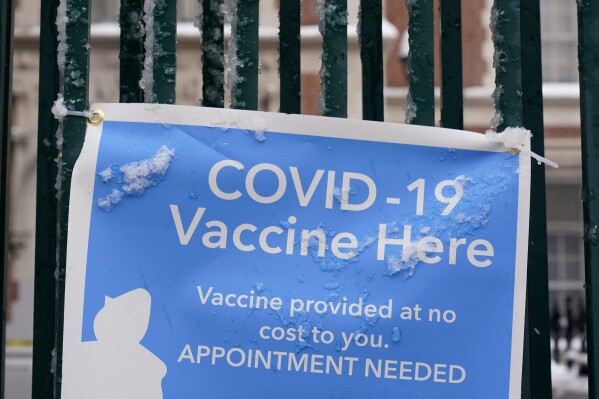 FILE - A sign advertises a COVID-19 vaccination site in New York, Feb. 2, 2021. A Brooklyn woman who pleaded guilty to fraud in connection with various pandemic-era relief schemes was sentenced Thursday, Feb 8, 2024, to three years of probation and $650,000 in penalties. (AP Photo/Seth Wenig, File)