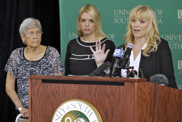 University of South Florida Associate Professor Erin Kimmerle, right, gestures as she stands with Florida Attorney General Pam Bondi, center, and Ovell Krell during a news conference Thursday, Aug. 7, 2014, at the University of South Florida in Tampa, Fla., regarding the unmarked graves found at the former Arthur G. Dozier School for Boys in Marianna Fla. University researchers have positively identified the remains of George Owen Smith, through a DNA match with his sister Ovell Krell, as one of the first to be exhumed from the 55 unmarked graves.  Smith was 14 when he disappeared from the school in 1940. (AP Photo/Chris O'Meara)