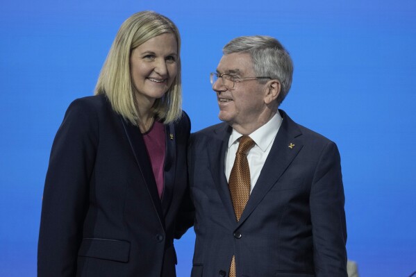 IOC President Thomas Bach, right, greets Kirsty Coventry after she was announced as the new IOC President at the International Olympic Committee 144th session in Costa Navarino, western Greece, Thursday, March 20, 2025. (AP Photo/Thanassis Stavrakis, File)