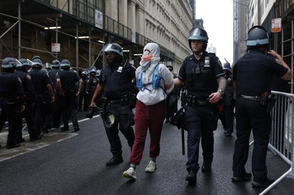 New York Police officers escort a protestor after making an arrest during a protest outside a federal building, Saturday, June 14, 2025, in New York. (AP Photo/Stefan Jeremiah)