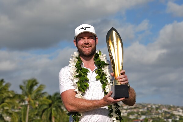 FILE -Grayson Murray holds the trophy after winning the Sony Open golf event, Sunday, Jan. 14, 2024, at Waialae Country Club in Honolulu. Two-time PGA Tour winner Grayson Murray died Saturday morning, May 25, 2024 at age 30, one day after he withdrew from the Charles Schwab Cup Challenge at Colonial(AP Photo/Matt York, File)