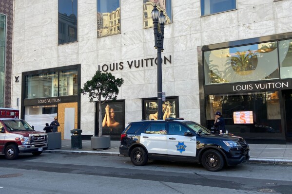 FILE - Police officers and emergency crews park outside the Louis Vuitton store in San Francisco's Union Square on Nov. 21, 2021, after looters ransacked businesses. California is making an unprecedented investment of more than $265 million in efforts to combat smash-and-grabs. (Danielle Echeverria/San Francisco Chronicle via AP, File)