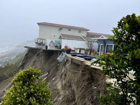 In this image provided by the Orange County Fire Authority, cliffside homes in San Clemente, Calif. on Wednesday, March 15, 2023, were evacuated due to the landslide in the rear. California's 11th atmospheric river of the winter has taken parting shots at southern counties as it moves out after walloping the storm-battered state. A landslide in coastal San Clemente has forced evacuation of four hilltop apartment buildings. (Orange County Fire Authority via AP)