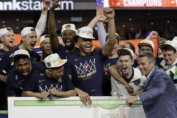 
              Virginia head coach Tony Bennett celebrates with his team after defeating Texas Tech 85-77 in the overtime in the championship of the Final Four NCAA college basketball tournament, Monday, April 8, 2019, in Minneapolis. (AP Photo/Matt York)
            