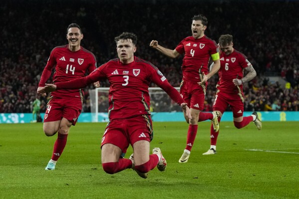 Wales' Neco Williams, foreground, celebrates after scoring his team second goal during the UEFA European Championship play-off match against Finland at the Cardiff City Stadium in Cardiff, Wales, Thursday, March 21, 2024. (AP Photo/Alastair Grant)