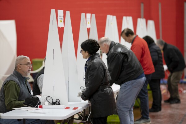 Voters check in to cast ballots in the New Hampshire presidential primary at a polling site in Derry, N.H., Jan. 23, 2024. (AP Photo/David Goldman, File)