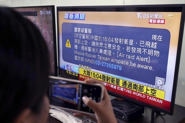 A TV monitor in Taipei, Taiwan flashes news that a satellite launched from China passed over southern Taiwan, Tuesday, Jan. 9, 2024. Taiwan’s defense ministry issued an alert Tuesday saying China has launched a satellite and urging caution days before the island's elections. (Kyodo News via AP)