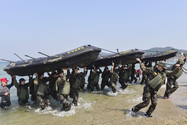 FILE - Members of South Korean women's national handball team perform a team-building exercise with rubber boats during a training at a boot camp for the Marine Corps in Pohang, South Korea, on March 30, 2016. South Korea’s Olympic chief has defended a decision to send hundreds of athletes to a military camp next week as part of preparations for the 2024 Games in Paris, citing a need to instill mental toughness in competitors.(Choe Dong-joon/Newsis via AP, File)