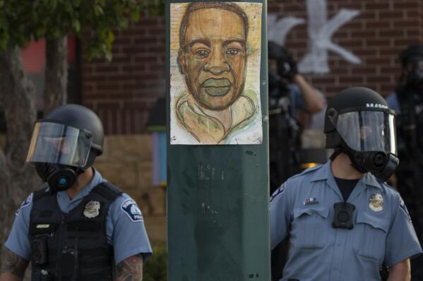 FILE - Minneapolis police stand outside the department's 3rd Precinct on May 27, 2020, in Minneapolis. President Joe Biden plans to sign an executive order on policing on Wednesday, the second anniversary of George Floyd's death. That's according to three people familiar with the matter who spoke on condition of anonymity to preview the matter. The executive order includes changes to policies on use of force and restrictions on the flow of surplus military hardware to local police. (Carlos Gonzalez/Star Tribune via AP, File)