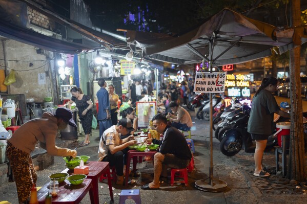 People dine on a sidewalk in Ho Chi Minh City, Vietnam, Jan. 11, 2024. (AP Photo/Jae C. Hong)