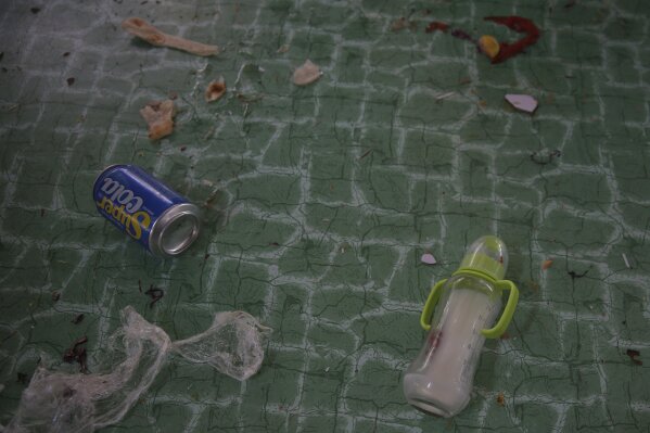 An empty soda can and a milk bottle lie among other debris at a damaged Dubai City wedding hall after an explosion in Kabul, Afghanistan, Sunday, Aug. 18, 2019.  A suicide-bomb blast ripped through a wedding party on a busy Saturday night. (AP Photo/Rafiq Maqbool)