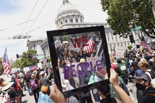 Rachel Podolsky holds a mirror as she marches towards City Hall during the "No Kings Day" protest in San Francisco on Saturday, June 14, 2025. (Scott Strazzante/San Francisco Chronicle via AP)