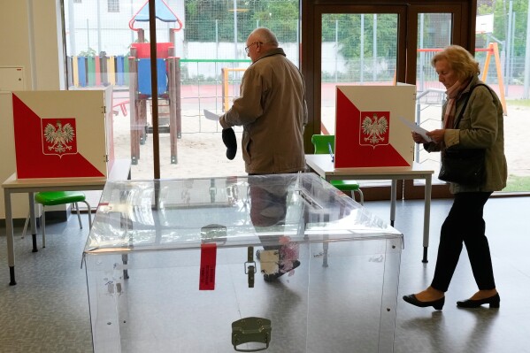 Voters cast their ballots shortly after polling stations opened in the first round of Poland's presidential elections in Łomianki, near Warsaw, on Sunday, May 18, 2025. (AP Photo/Czarek Sokolowski)