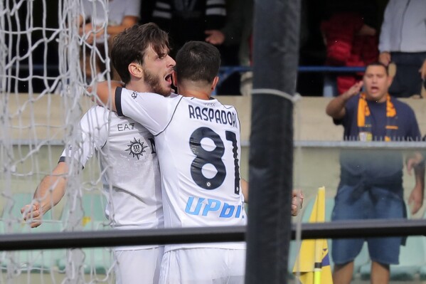 Napoli's Khvicha Kvaratskhelia, left, celebrates scoring during the Serie A soccer match between Hellas Verona and Napoli at Marcantonio Bentegodi Stadium. in Verona, Italy, Saturday Oct. 21, 2023. (Paola Garbuio/LaPresse via AP)