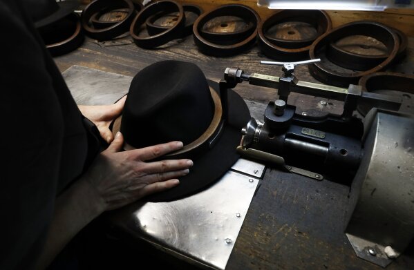 
              A man holds a hat inside the Borsalino hat factory, in Spinetta Marengo, near Alessandria, Italy, Thursday, Jan. 17, 2019. Borsalino's prized felt hats are handmade by 80 workers in its Piemonte factory, many who have worked there for decades, with original machinery that use hot water and steam to transform rabbit fur into highly prized felt, that is formed into clochards, dyed and molded by hand to create the latest styles.  (AP Photo/Antonio Calanni)
            