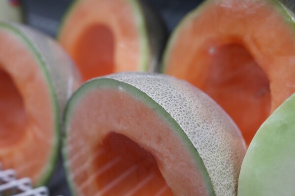 Cantaloupe halves are displayed for sale at a supermarket in New York on Tuesday, Dec. 12, 2023. In 2023, hundreds of people in the U.S. and Canada have been sickened in a growing outbreak of salmonella poisoning linked to contaminated whole and pre-cut cantaloupe. (AP Photo/Mary Conlon)