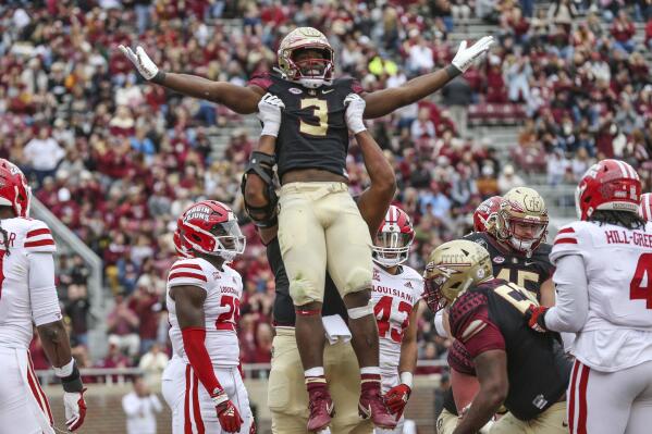 Florida State running back Trey Benson (3) is lifted, in celebration of his touchdown, by offensive lineman Jazston Turnetine during the third quarter of an NCAA college football game against Louisiana on Saturday, Nov. 19, 2022, in Tallahassee, Fla. (AP Photo/Gary McCullough)