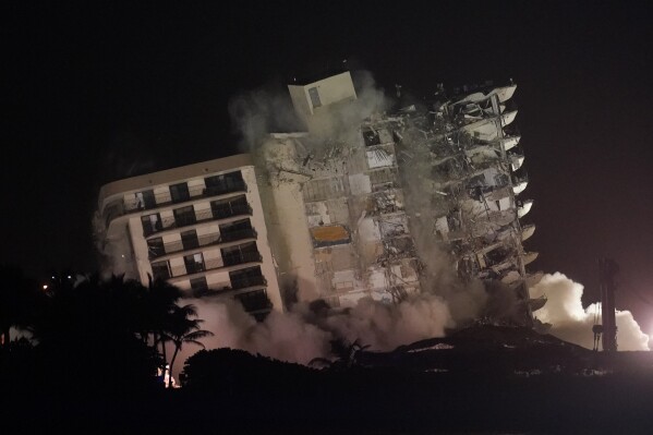 The damaged remaining structure at the Champlain Towers South condo building collapses in a controlled demolition, July 4, 2021, in Surfside, Fla. (AP Photo/Lynne Sladky, File)