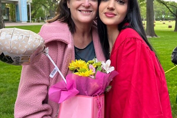 In this undated photo provided by Rabbi Meir Hecht on behalf of the Raanan family is Judith Raanan, left, and her daughter Natalie, 18, after Natalie's recent high school graduation. Judith and Natalie are missing while visiting relatives in Nahal Oz for Simchat Torah, a festive Jewish holiday that marks the conclusion of the annual reading of the Torah. (Raanan Family via AP)