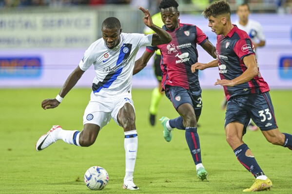 Milan's Marcus Thuram, left, and Cagliari's Adam Obert, right, challenge for the ball during the Serie A soccer match between Cagliari Calcio and Inter Milan in Cagliari, Italy, Monday, Aug. 28, 2023. (Gianluca Zuddas/LaPresse via AP)
