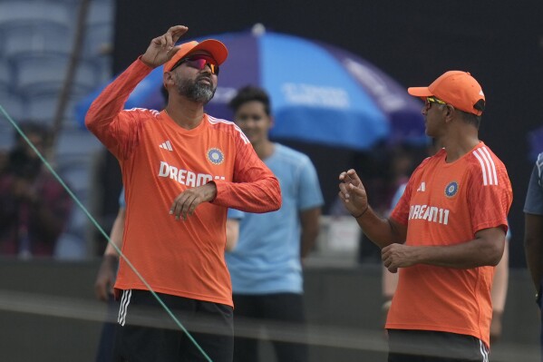 India's bowling coach Paras Mhambrey, left, speaks with India's head coach Rahul Dravid during a training session ahead of the ICC cricket world cup match against Bangladesh in Pune, India, Wednesday, Oct. 18, 2023. (AP Photo/Rafiq Maqbool)