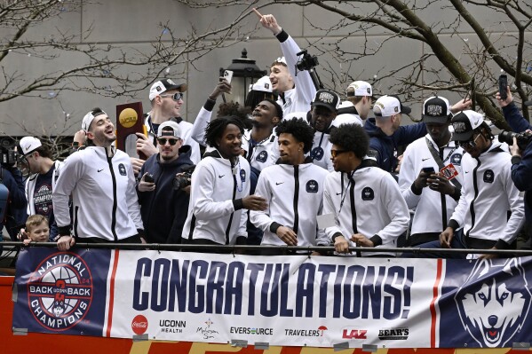 UConn players ride on a double decker bus during a parade to celebrate the team's NCAA college basketball championship, Saturday, April 13, 2024, in Hartford, Conn. (AP Photo/Jessica Hill)